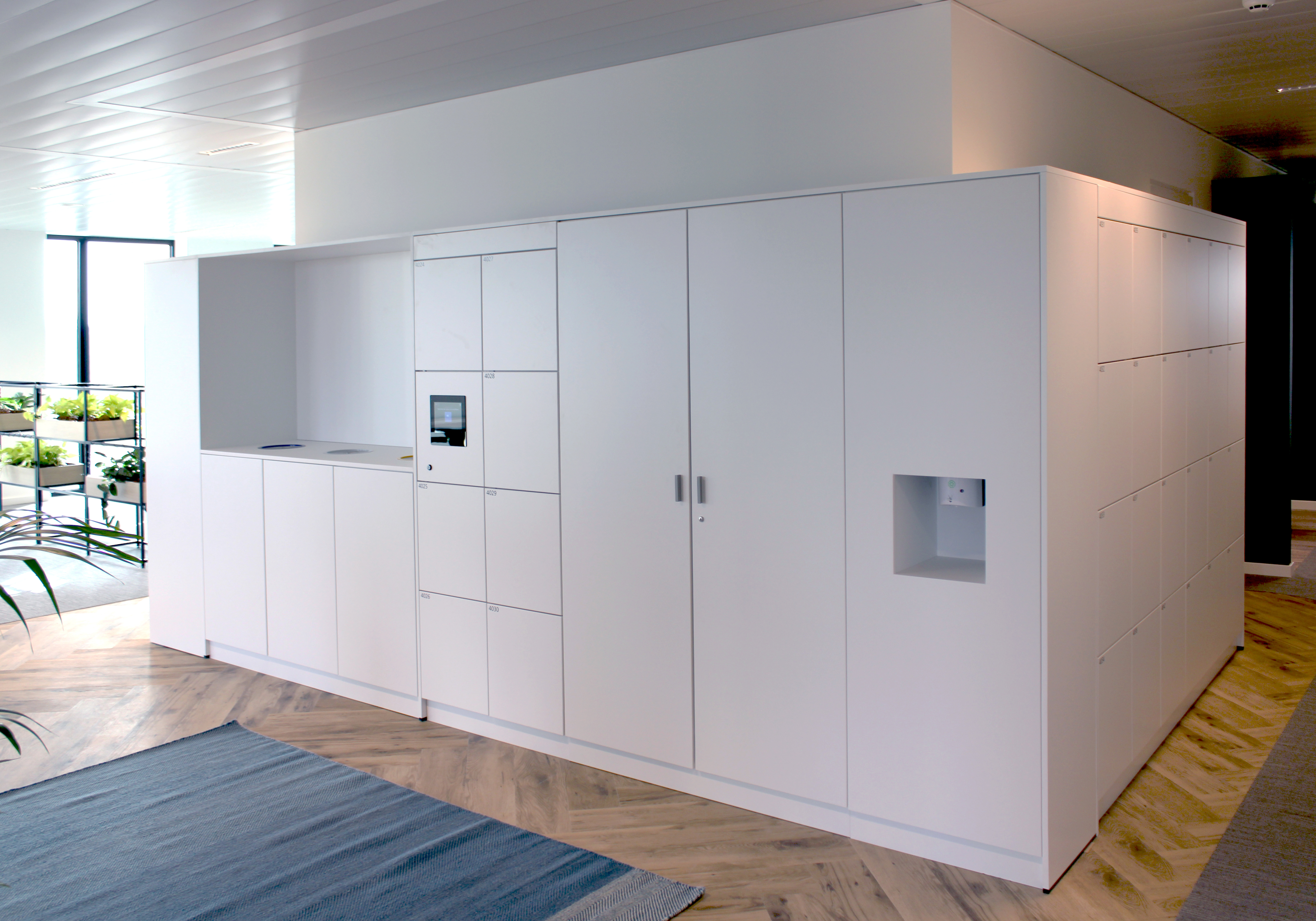 Medewerker die aan het begin van de werkdag zijn laptop en tas opbergt in een persoonlijke locker in een moderne kantooromgeving