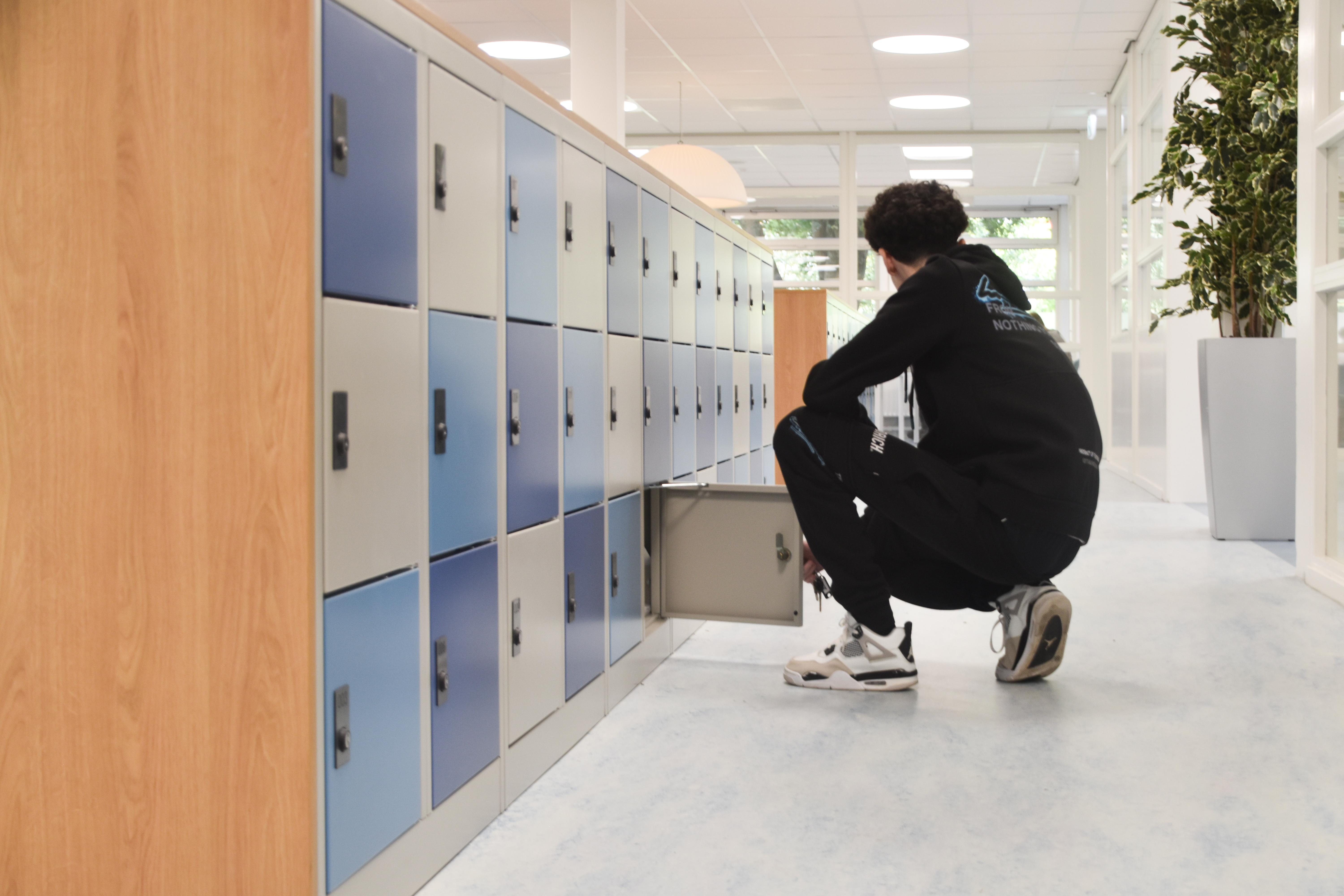 Leerling bergt schoolspullen op in persoonlijke locker voor overzicht en verantwoordelijkheid